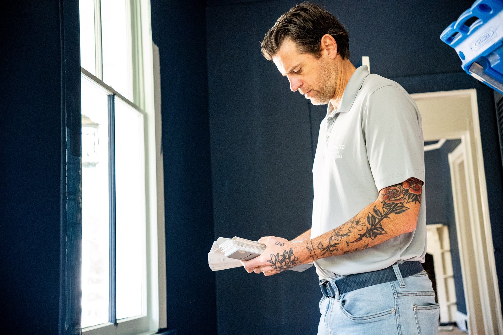 Greg checking a colour sample in a navy-painted room