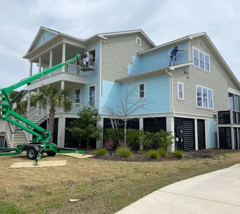 A lift at work on a raised coastal house exterior